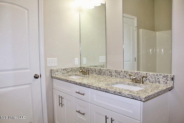 full bathroom with double vanity and a sink