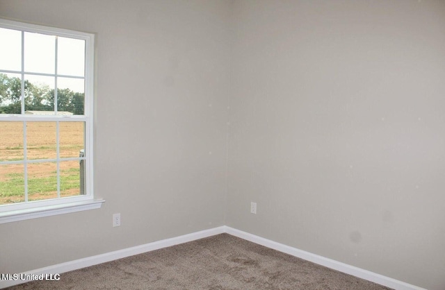 carpeted spare room with baseboards