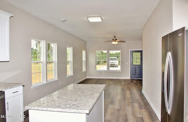 kitchen featuring a ceiling fan, dark wood-style flooring, a wealth of natural light, stainless steel appliances, and white cabinets