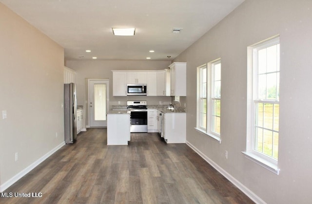 kitchen featuring stainless steel appliances, white cabinetry, dark wood-type flooring, and visible vents