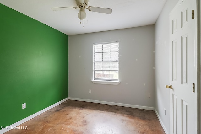 empty room featuring concrete floors, a ceiling fan, and baseboards