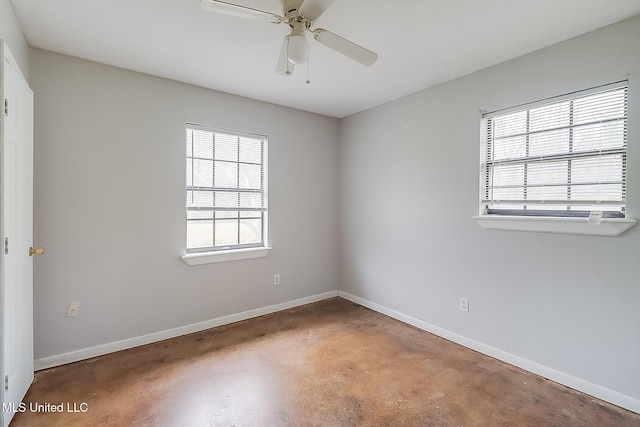 unfurnished room featuring concrete floors, baseboards, and ceiling fan