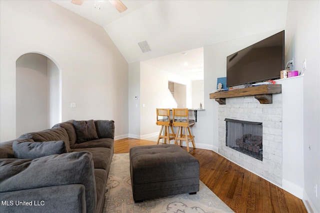 4943 W Margarette Cir, Olive Branch, MS 38654 - living area with a ceiling fan, wood finished floors, a stone fireplace, arched walkways, and lofted ceiling