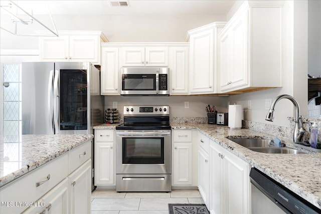 4943 W Margarette Cir, Olive Branch, MS 38654 - kitchen featuring stainless steel appliances, a sink, white cabinets, light tile patterned floors, and light stone countertops