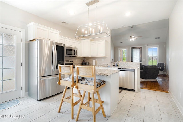 4943 W Margarette Cir, Olive Branch, MS 38654 - kitchen with appliances with stainless steel finishes, a peninsula, ceiling fan, light stone countertops, and baseboards