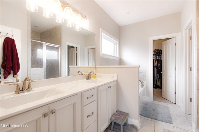 4943 W Margarette Cir, Olive Branch, MS 38654 - bathroom featuring a shower stall, double vanity, a garden tub, a spacious closet, and tile patterned flooring