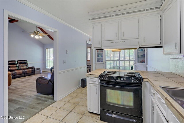 5530 Spencer Dr, Jackson, MS 39212 - kitchen with electric range, a ceiling fan, a wainscoted wall, under cabinet range hood, and tile counters