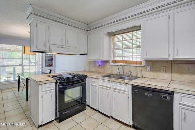 5530 Spencer Dr, Jackson, MS 39212 - kitchen featuring light tile patterned floors, a sink, a peninsula, under cabinet range hood, and black appliances