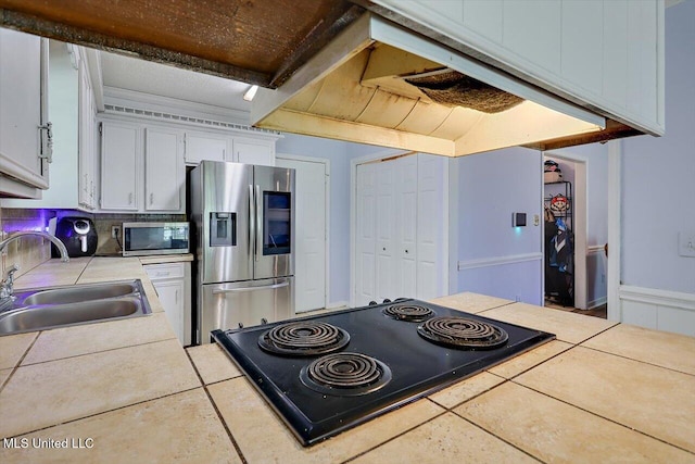5530 Spencer Dr, Jackson, MS 39212 - kitchen featuring tile countertops, a sink, white cabinetry, and stainless steel appliances