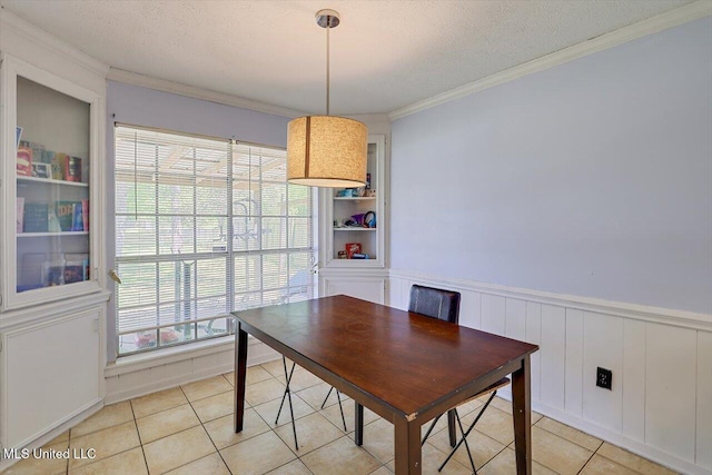 5530 Spencer Dr, Jackson, MS 39212 - dining space featuring wainscoting, a textured ceiling, ornamental molding, and light tile patterned flooring