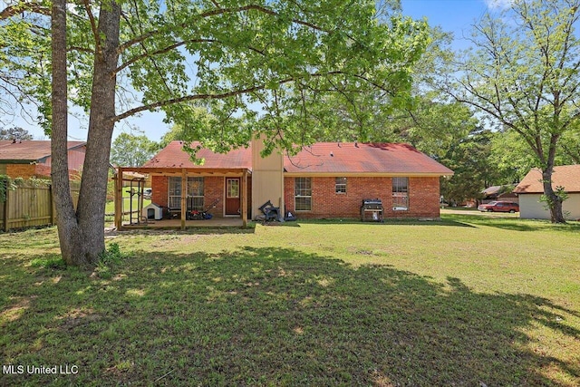5530 Spencer Dr, Jackson, MS 39212 - back of house with brick siding, a patio area, fence, and a lawn