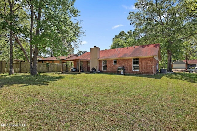 5530 Spencer Dr, Jackson, MS 39212 - back of house featuring a chimney, cooling unit, brick siding, a yard, and fence