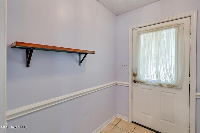 5530 Spencer Dr, Jackson, MS 39212 - entryway featuring light tile patterned floors, baseboards, and a textured ceiling