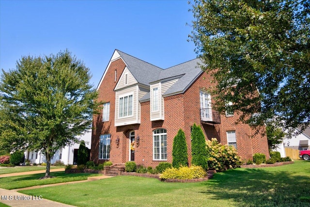 view of front of home with a front yard and a balcony