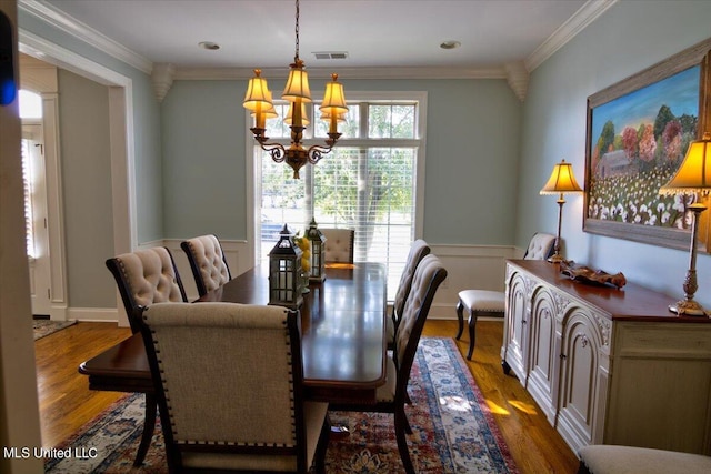 dining room with a wealth of natural light, ornamental molding, dark wood-type flooring, and a chandelier