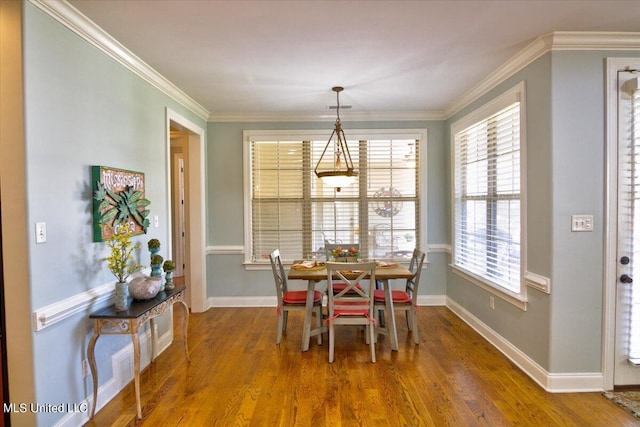 dining area featuring ornamental molding, wood-type flooring, and plenty of natural light