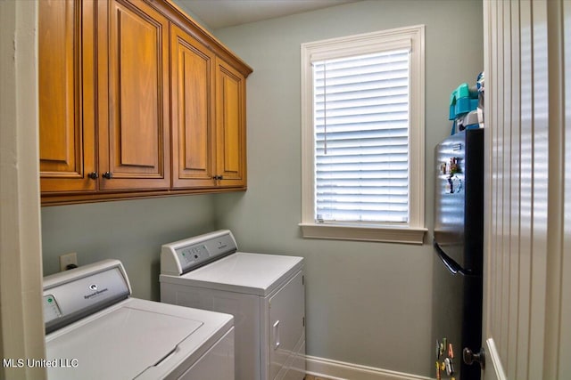 washroom with cabinets, a healthy amount of sunlight, and washing machine and dryer