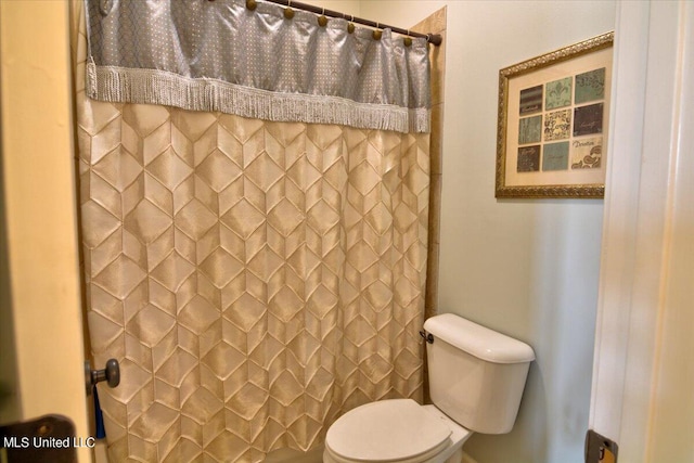 bathroom with toilet and a shower with shower curtain