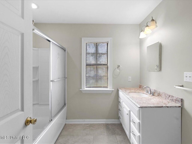 full bathroom featuring tile patterned flooring, vanity, baseboards, and bath / shower combo with glass door