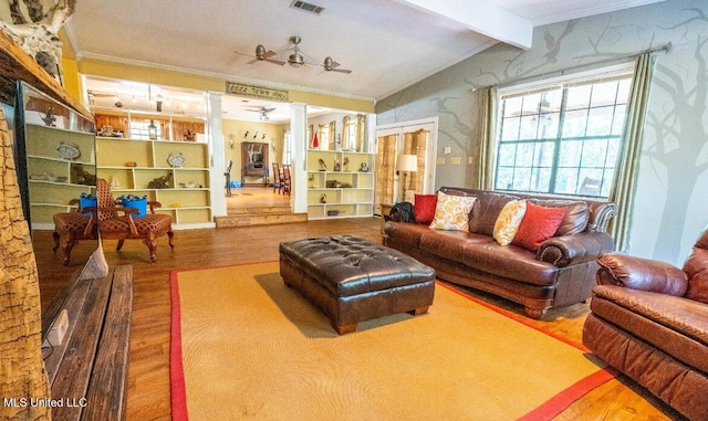 living room with ceiling fan, lofted ceiling with beams, wood-type flooring, and ornamental molding