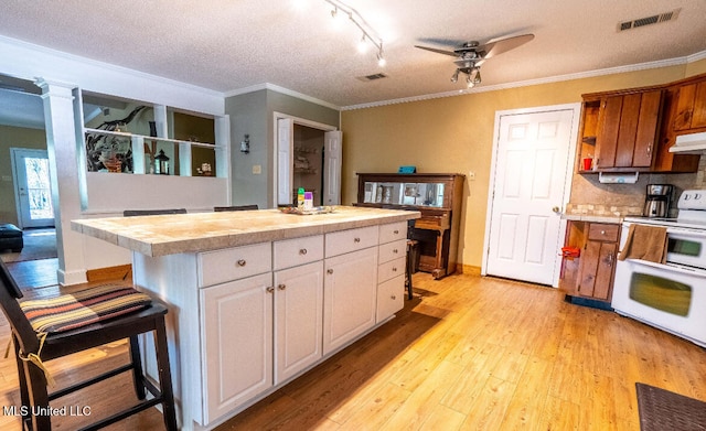 kitchen featuring white cabinets, ceiling fan, white electric range oven, a kitchen bar, and light wood-type flooring