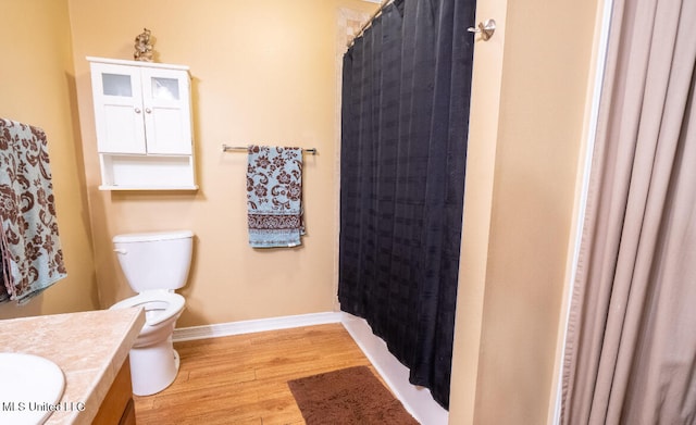 bathroom featuring vanity, hardwood / wood-style floors, curtained shower, and toilet