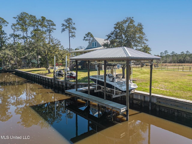 dock area featuring a water view, boat lift, and a yard