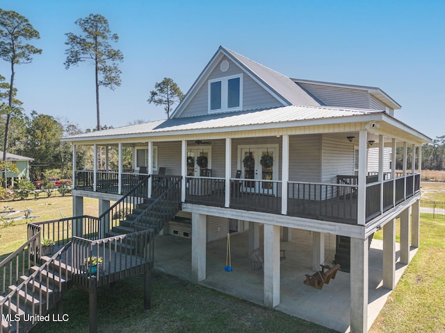 view of front of house featuring stairs, metal roof, french doors, and a patio