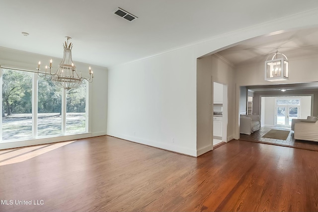 interior space featuring arched walkways, wood finished floors, visible vents, and an inviting chandelier