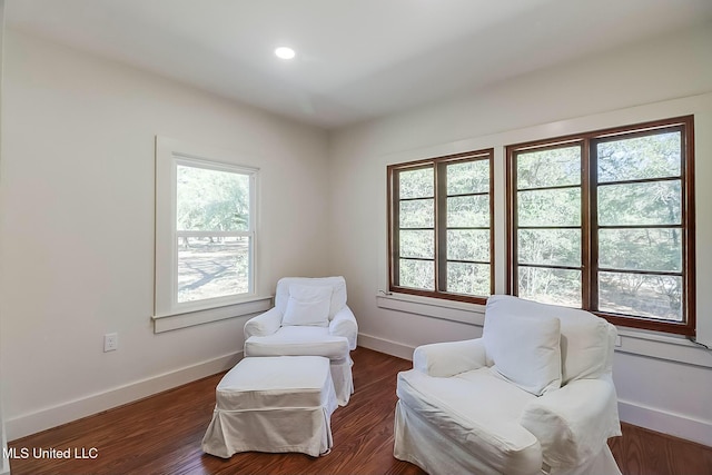 living area with plenty of natural light, wood finished floors, and baseboards