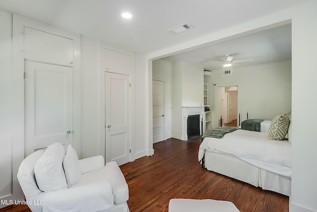 bedroom with a fireplace, wood finished floors, visible vents, and recessed lighting