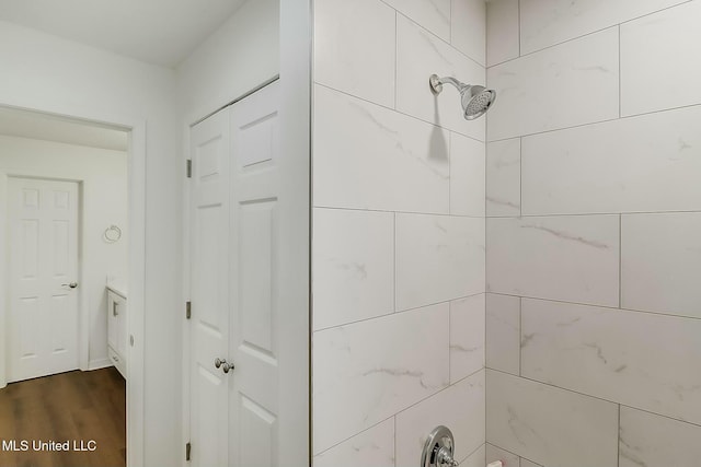 room details with a tile shower and wood finished floors