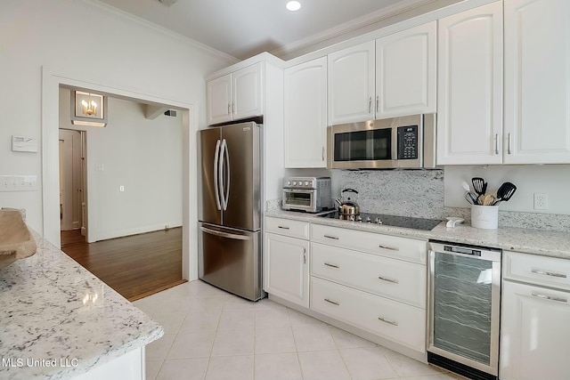 kitchen featuring appliances with stainless steel finishes, beverage cooler, white cabinets, and ornamental molding