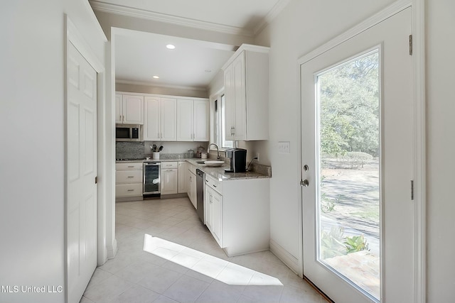 kitchen featuring beverage cooler, stainless steel appliances, a sink, and crown molding