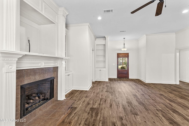 unfurnished living room with crown molding, a fireplace, ceiling fan, and dark hardwood / wood-style floors