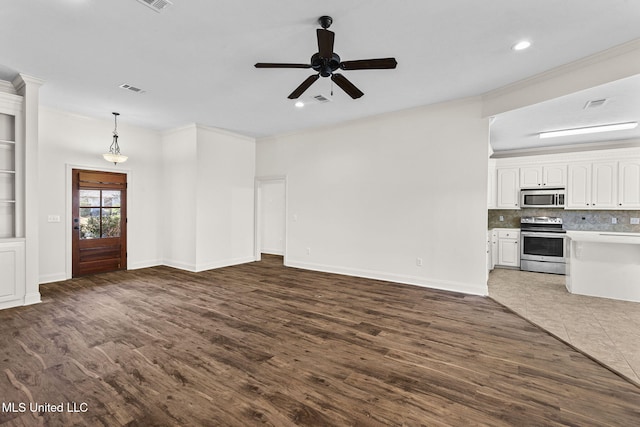 unfurnished living room featuring dark hardwood / wood-style floors, ceiling fan, and crown molding