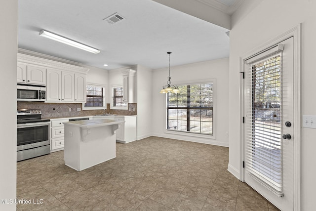 kitchen featuring a center island, an inviting chandelier, pendant lighting, stainless steel electric stove, and white cabinets