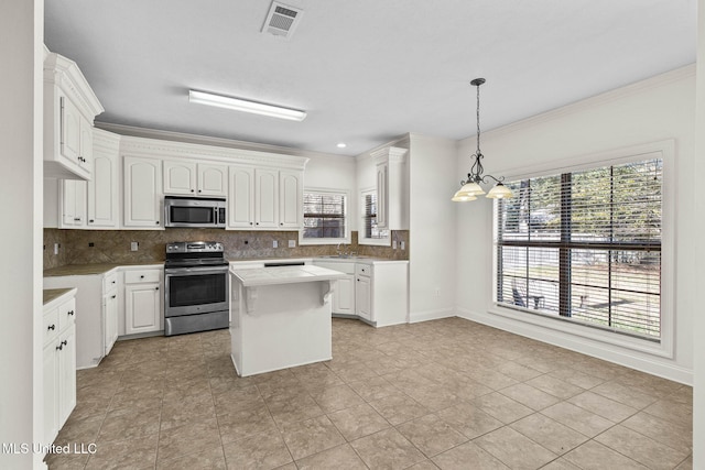 kitchen with white cabinetry, a notable chandelier, decorative light fixtures, a kitchen island, and appliances with stainless steel finishes