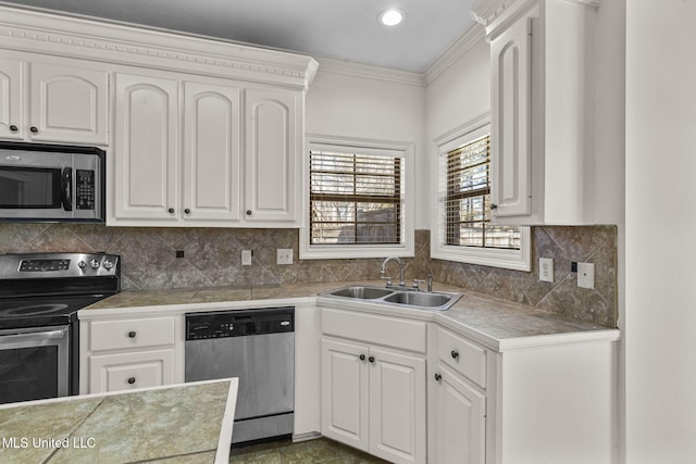 kitchen featuring appliances with stainless steel finishes, white cabinetry, tile counters, and sink