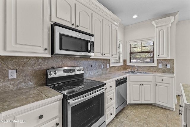 kitchen featuring crown molding, white cabinetry, sink, and stainless steel appliances