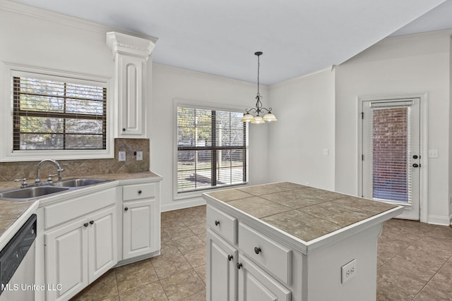 kitchen featuring decorative backsplash, stainless steel dishwasher, sink, white cabinets, and hanging light fixtures