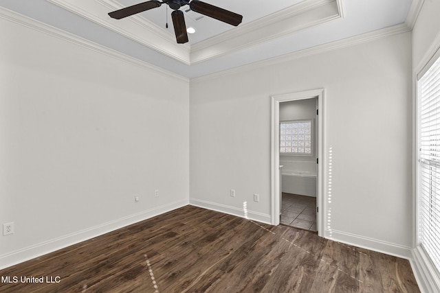 unfurnished bedroom with a tray ceiling, ensuite bath, ceiling fan, and crown molding