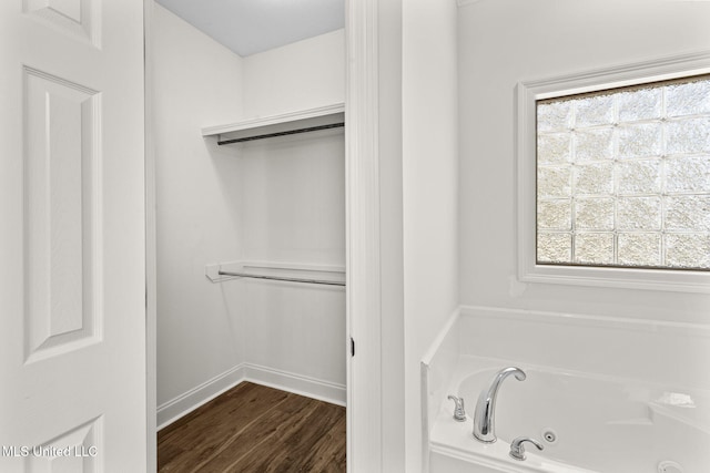 bathroom featuring hardwood / wood-style floors, a wealth of natural light, and a bathing tub