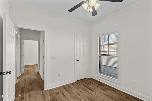 unfurnished bedroom featuring ceiling fan, crown molding, and dark wood-type flooring