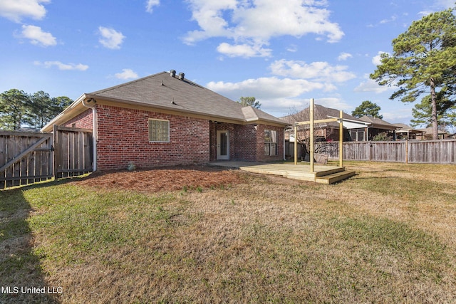 back of property featuring a yard and a wooden deck