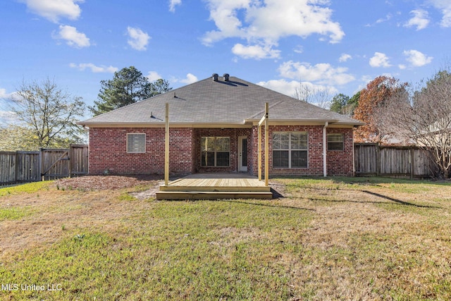 rear view of house with a lawn and a wooden deck