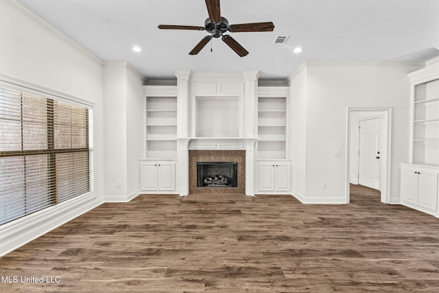 unfurnished living room with ceiling fan, dark hardwood / wood-style floors, crown molding, and a fireplace