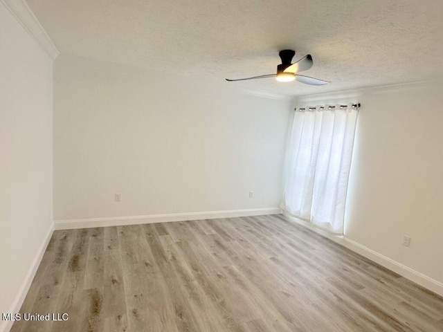 spare room featuring ceiling fan, baseboards, light wood-type flooring, and a textured ceiling