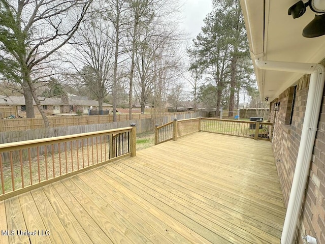 wooden terrace with a fenced backyard