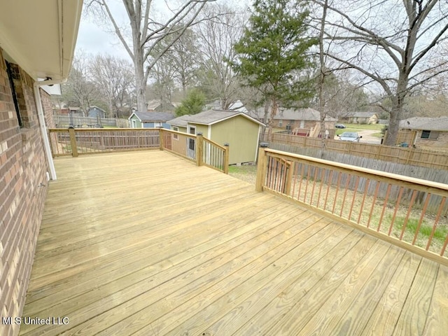 deck featuring a residential view, an outdoor structure, and fence